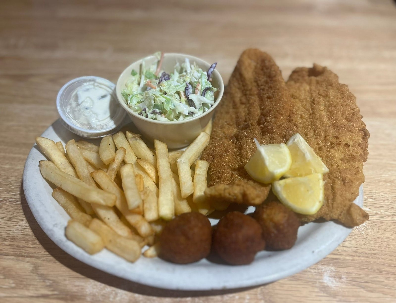 Fried catfish plate with fries, coleslaw and hush puppies